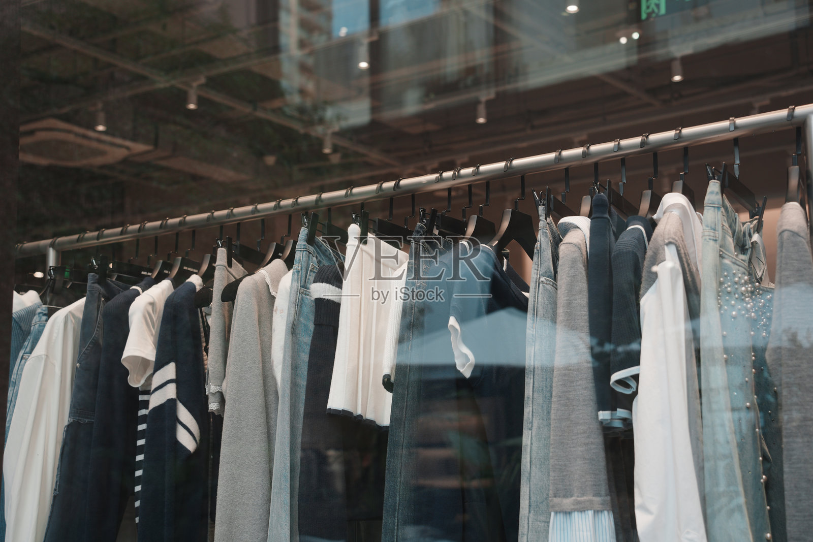 服装店橱窗内悬挂多款服饰陈列照片摄影图片
