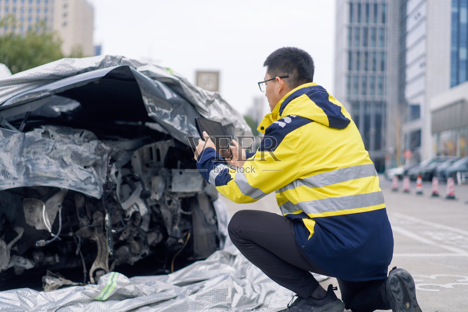 穿反光服人员蹲拍损毁车辆现场照片摄影图片