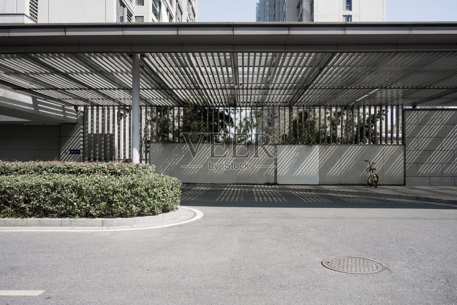 现代建筑廊架下空旷道路与绿植照片摄影图片