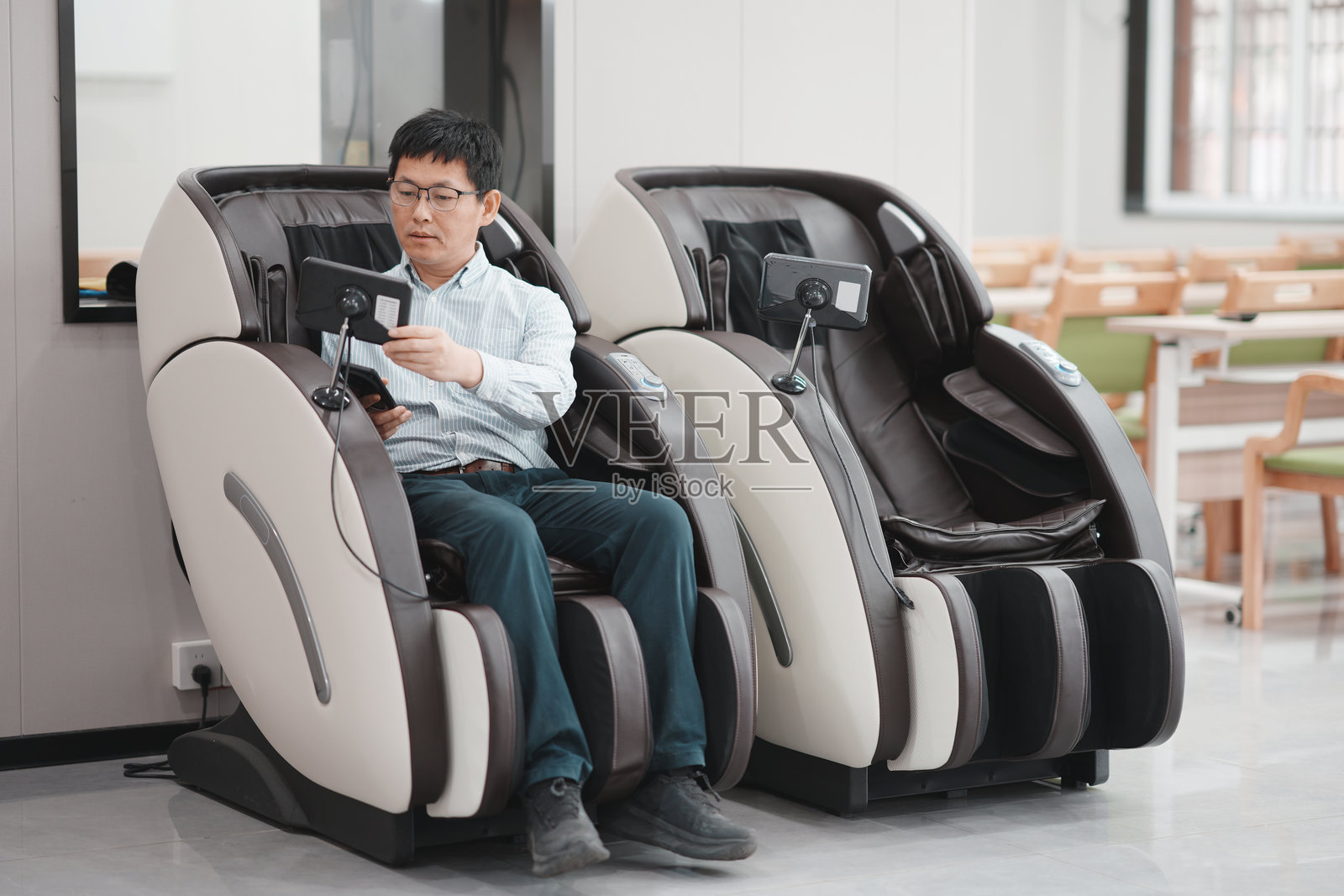 男子坐按摩椅看平板放松休闲场景照片摄影图片