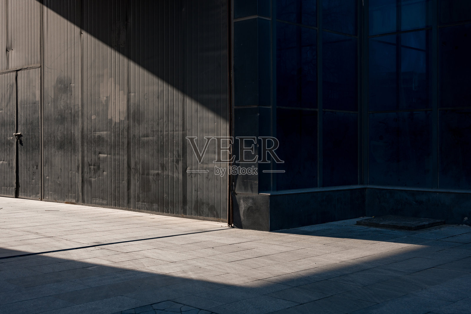 黑色金属墙与斜射光影构成街景照片摄影图片