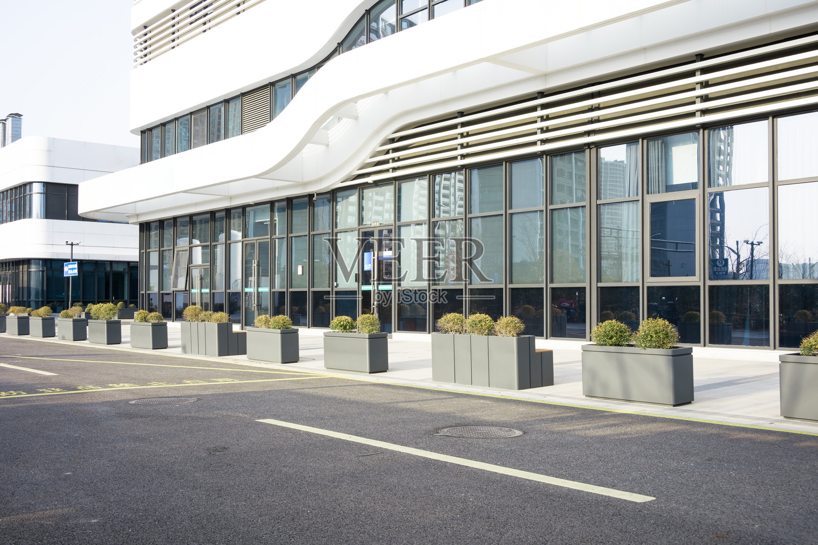 现代医院建筑外立面与绿化花箱街景照片摄影图片