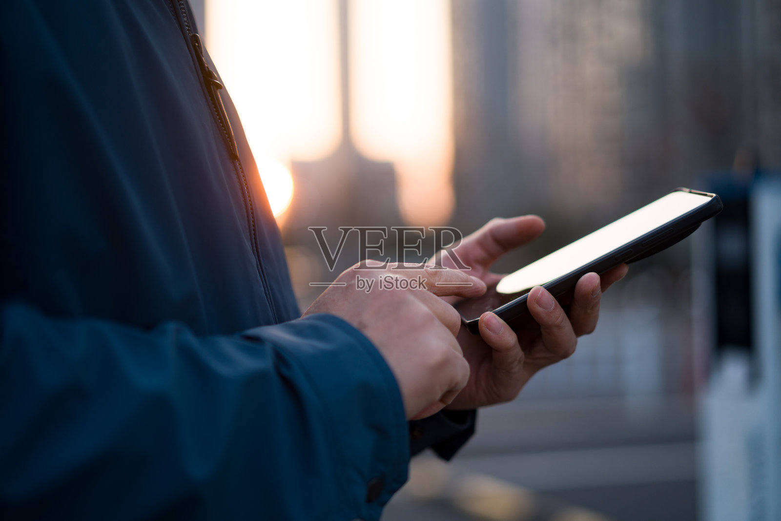 城市街头男子手持平板操作特写照片摄影图片