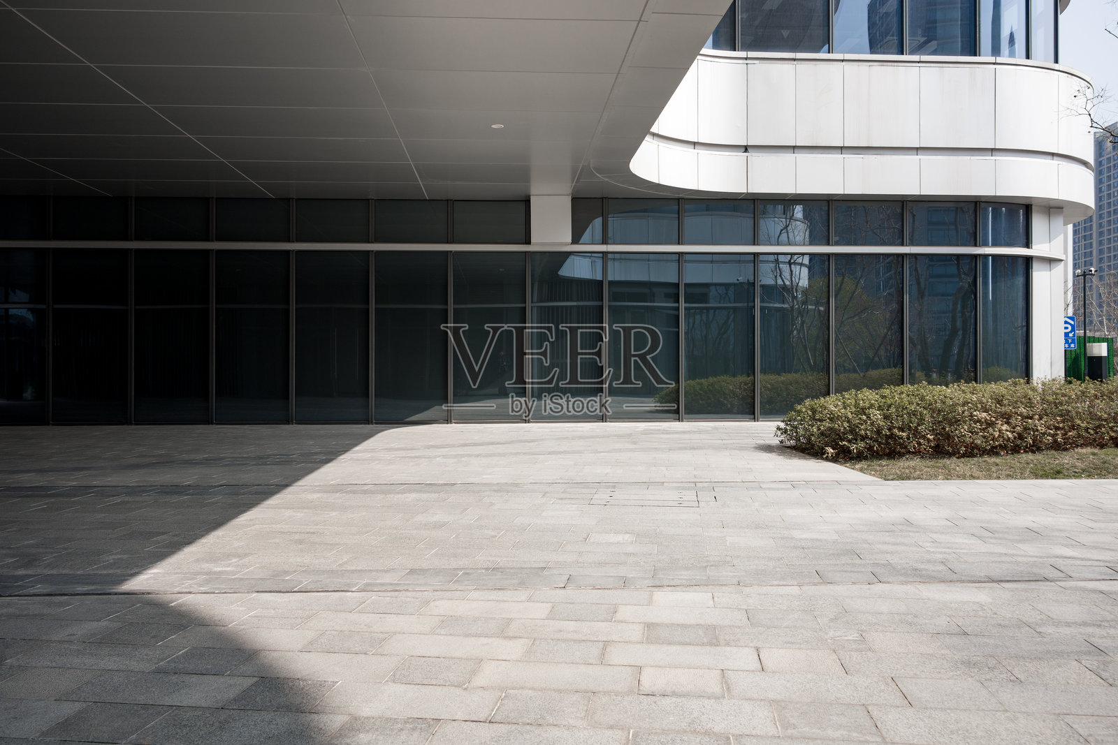 现代建筑玻璃幕墙与灰色铺地广场照片摄影图片