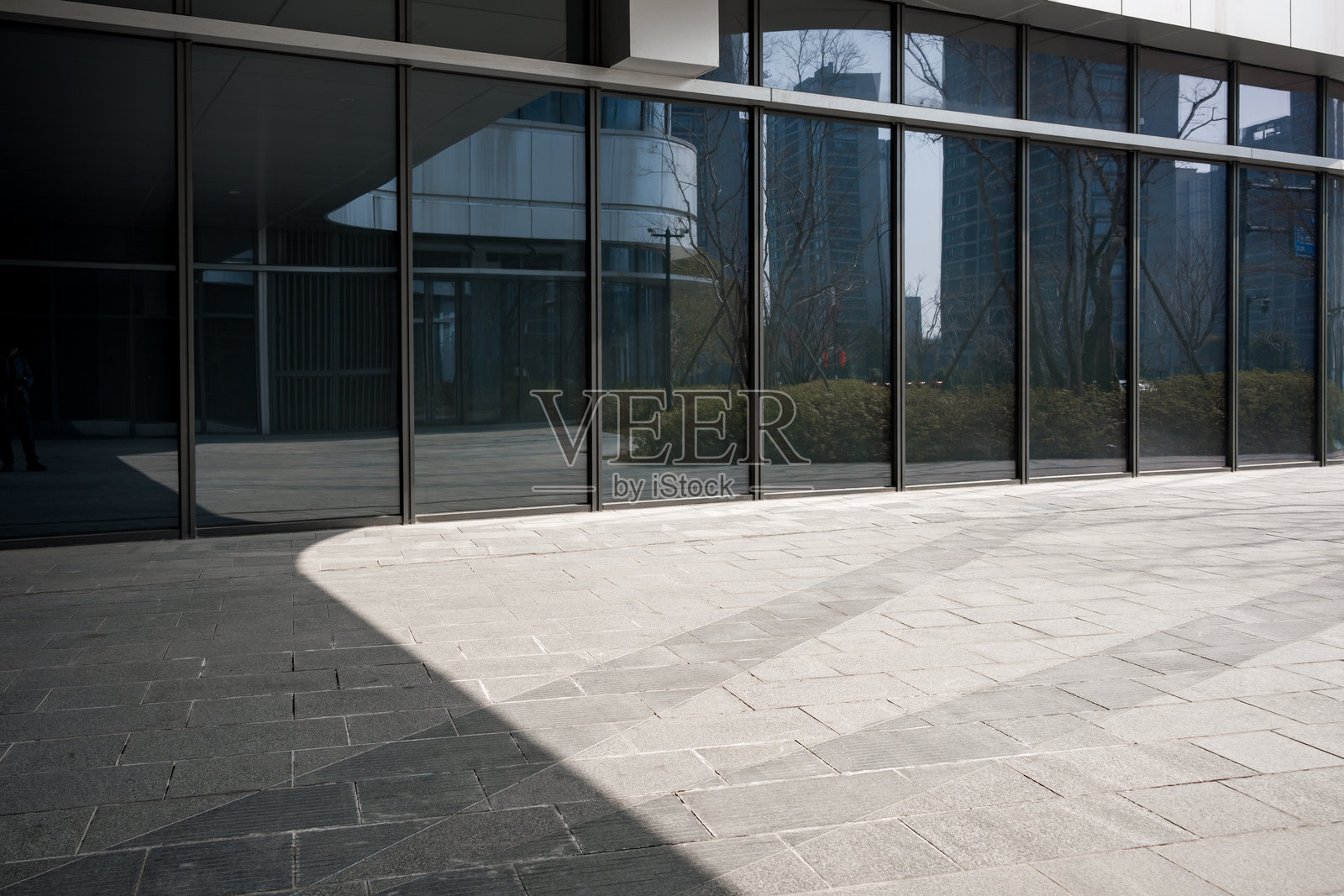 现代玻璃幕墙建筑外景与石板地面照片摄影图片