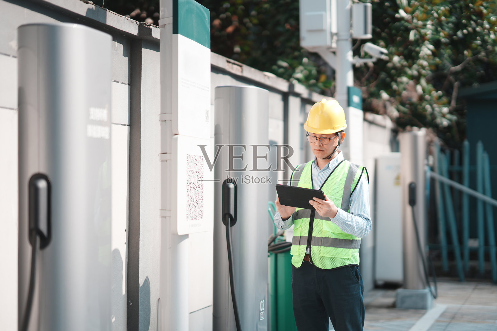 工程师佩戴安全帽检查充电桩设备照片摄影图片