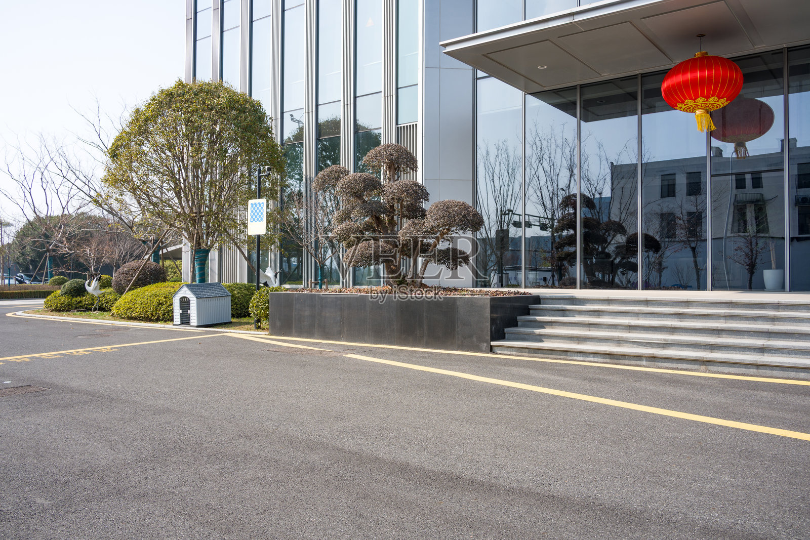 现代办公楼前红灯笼与修剪绿植景观照片摄影图片