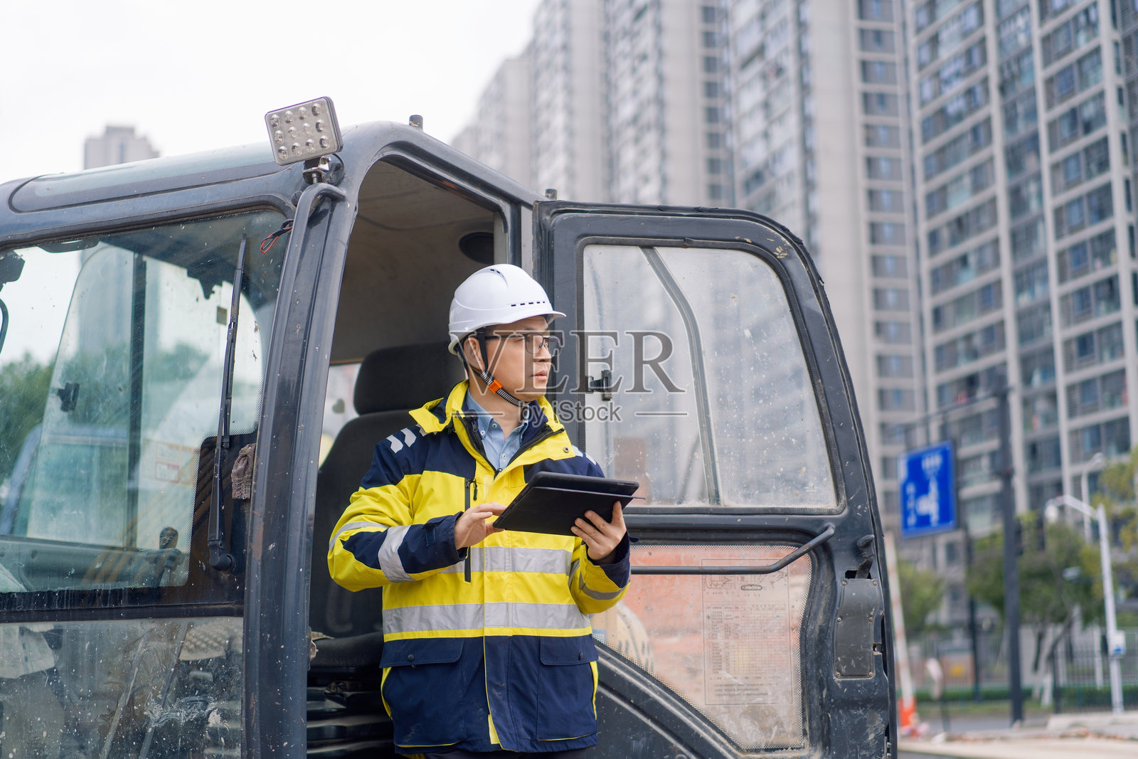 工地工程师手持平板检查挖掘机照片摄影图片