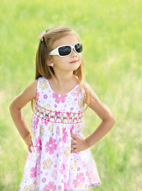 草地上戴着太阳镜的可爱小女孩图片下载