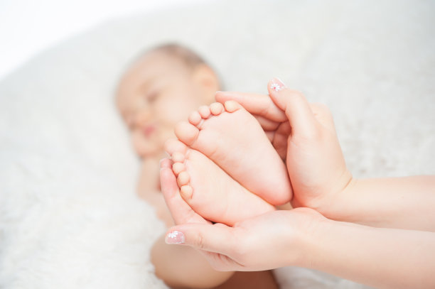 母亲的手抱着新生儿的脚图片下载
