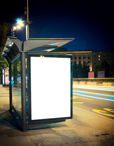 夜晚，空荡荡的城市街道上灯火通明的公交车站图片下载