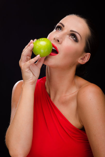 美丽快乐的女人吃着青苹果图片下载