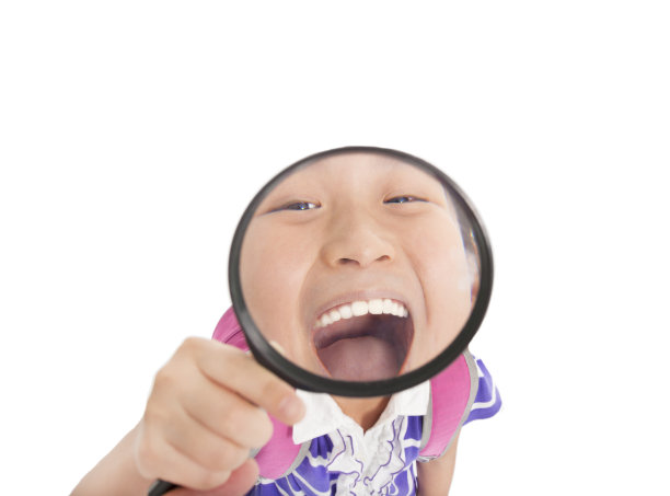 用放大镜拉近小女孩的牙齿图片下载