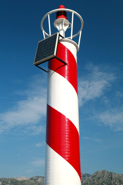 红白条纹的灯塔在多云的天空上图片下载