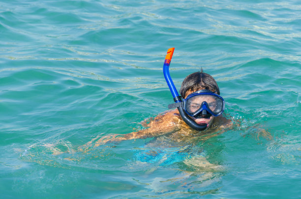 男孩戴着浮潜面罩戴着浮潜在海上图片下载