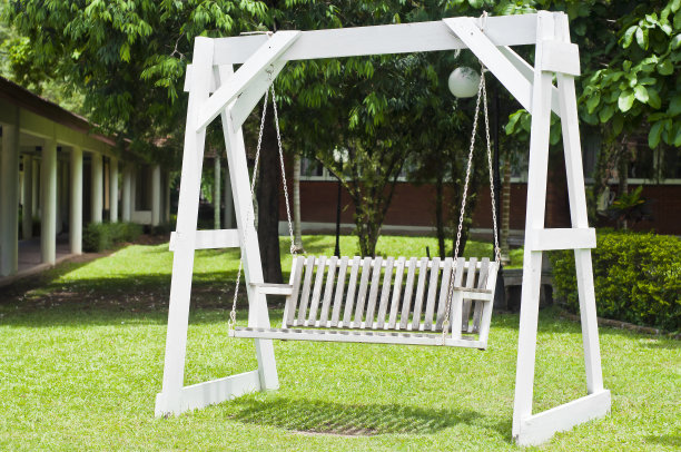 花园里的白色木制秋千。图片下载