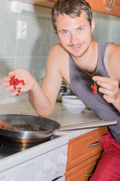 男人在煮醋栗酱。图片下载