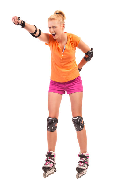 金发滑旱冰的女孩在空中挥拳。图片下载