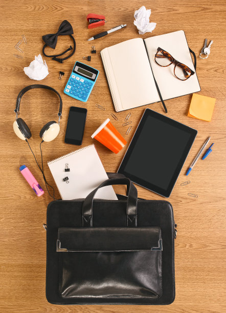 一个木桌上放着公事包里的东西。图片下载