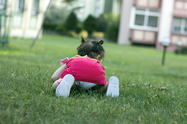 小女孩在草地上爬图片下载