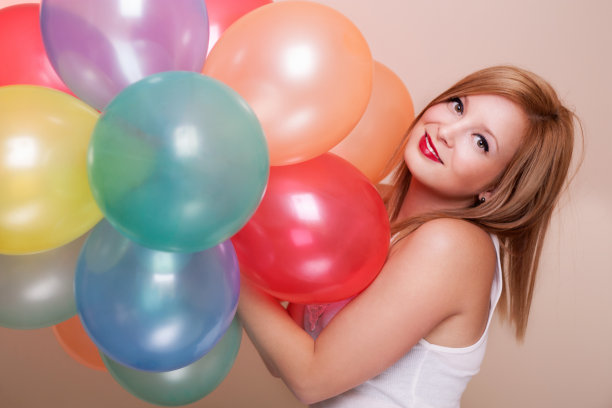 有吸引力的快乐的年轻女人与生日气球图片下载