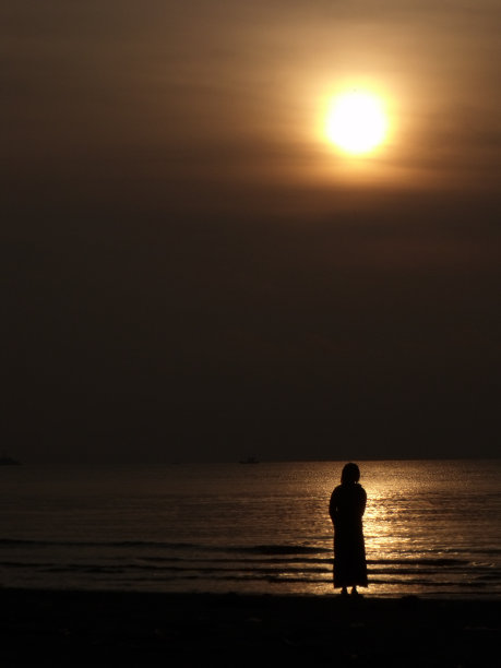 日落时海滩上的男人剪影图片下载