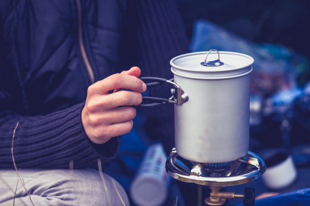 女人在便携式野营炉上烧水图片下载
