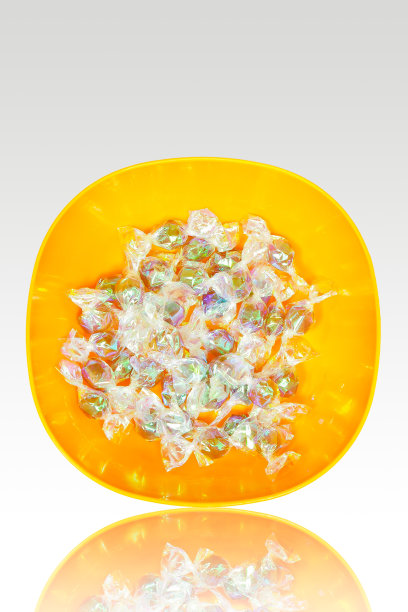 铝箔包装的糖果在橙色碗图片下载