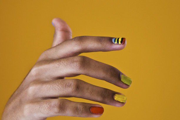 彩色女性指甲上的黄色背景图片下载