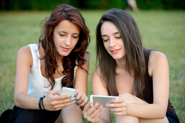 两个女孩在看智能手机图片下载