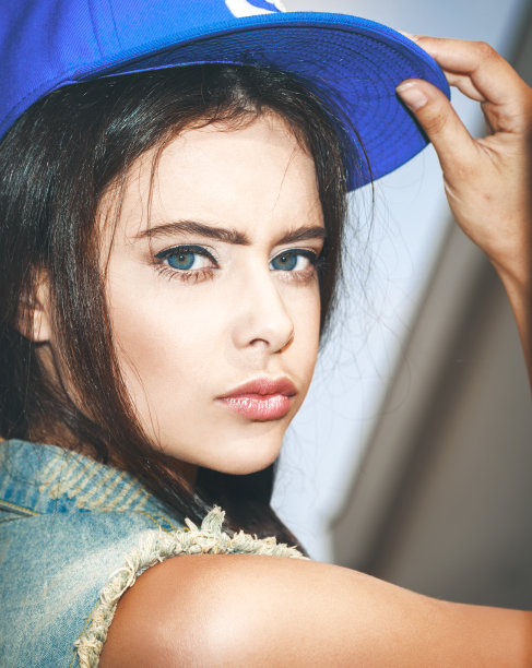 年轻性感的女人在蓝色的帽子的特写图片下载