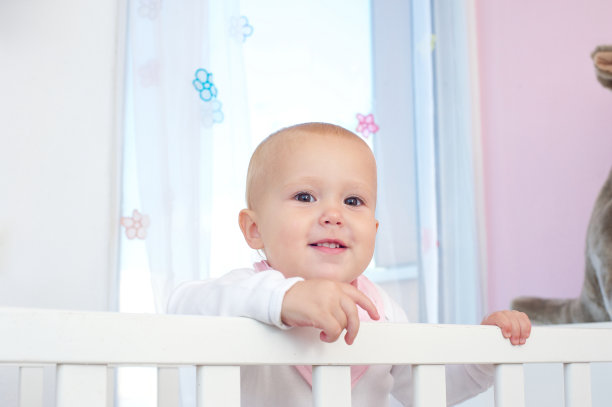 横向肖像的一个可爱的婴儿微笑在婴儿床图片下载