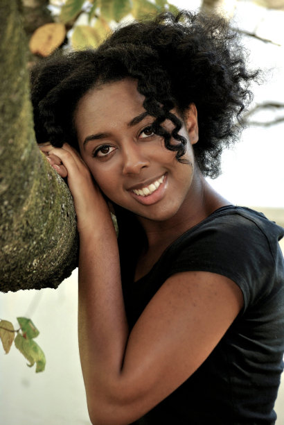 年轻女子在树枝上摆姿势图片下载