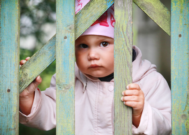 棕色眼睛的女婴戴着粉红色的帽子和木制的三柱门图片下载