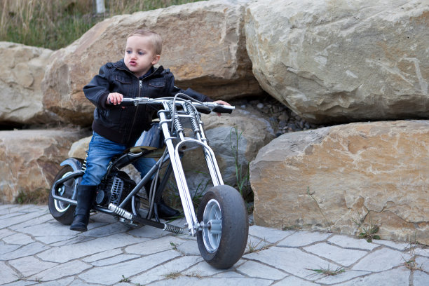 一个穿着摩托车服的婴儿在一辆小摩托车上图片下载