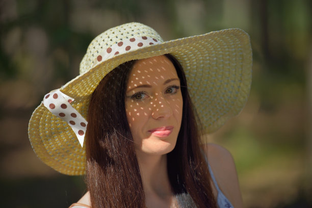 一个美丽的年轻女子戴着帽子在森林里的肖像图片下载