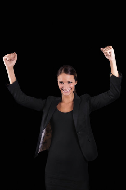 成功的白人妇女微笑着黑色礼服夹克手臂在空中图片下载