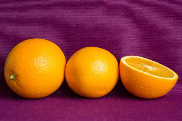紫罗兰色背景上的橙子图片下载