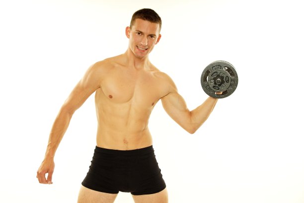 年轻的运动员拿着哑铃摆姿势图片下载