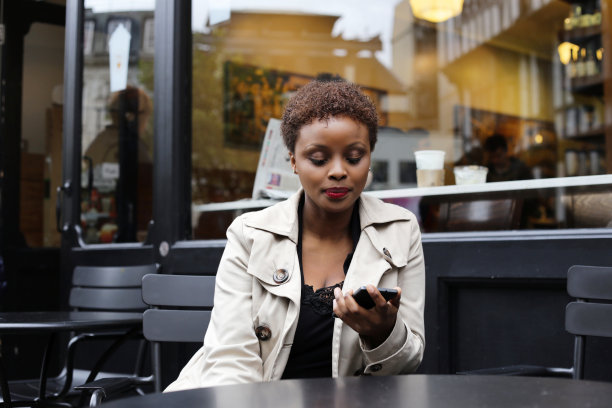美丽的女孩在看她的智能手机图片下载