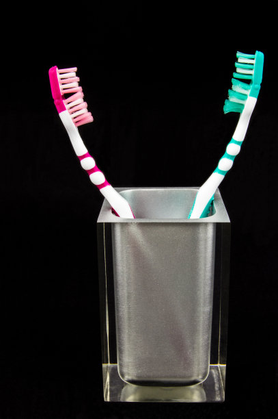 两把牙刷放在一个半透明的容器里图片下载