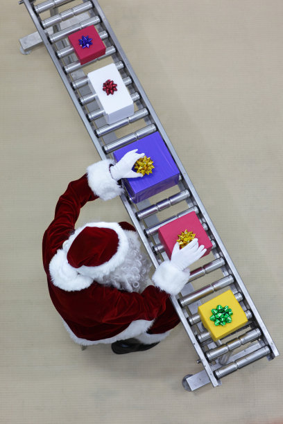 圣诞老人在礼物工厂的生产线上工作图片下载