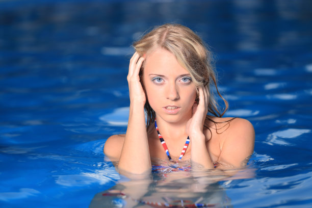 美丽的女人在游泳池摆姿势图片下载