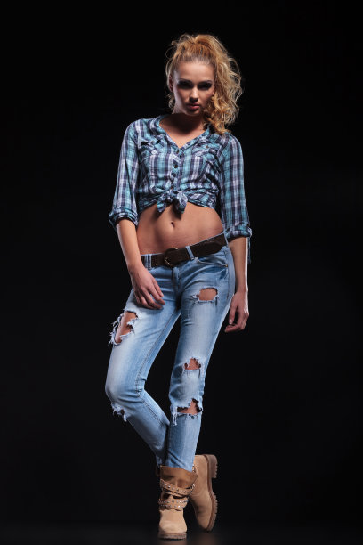 年轻性感的女人在牛仔裤和衬衫摆姿势图片下载