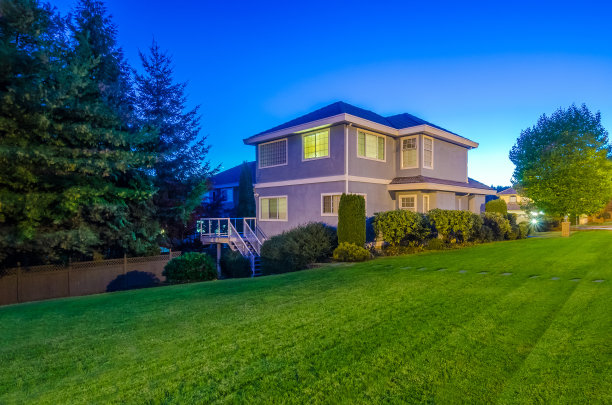 黄昏时分，一栋带漂亮花园的漂亮房子图片下载