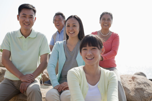 几代同堂的一家人坐在户外的岩石上，中国图片下载