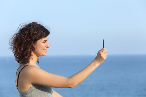 一个女人正在用手机拍照图片下载