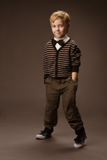 男孩在复古风格，儿童时尚，在棕色背景图片下载