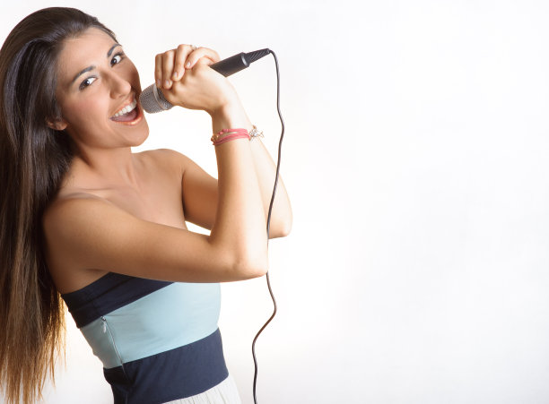 快乐美丽的女孩拿着麦克风唱歌图片下载