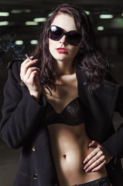 穿着内衣和外套的年轻漂亮的吸烟女孩图片下载
